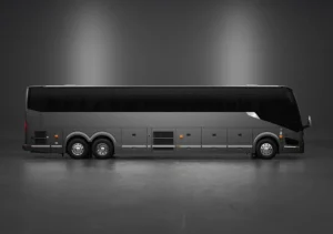 A modern, black coach bus with six wheels is parked in a studio with a plain, dark background.